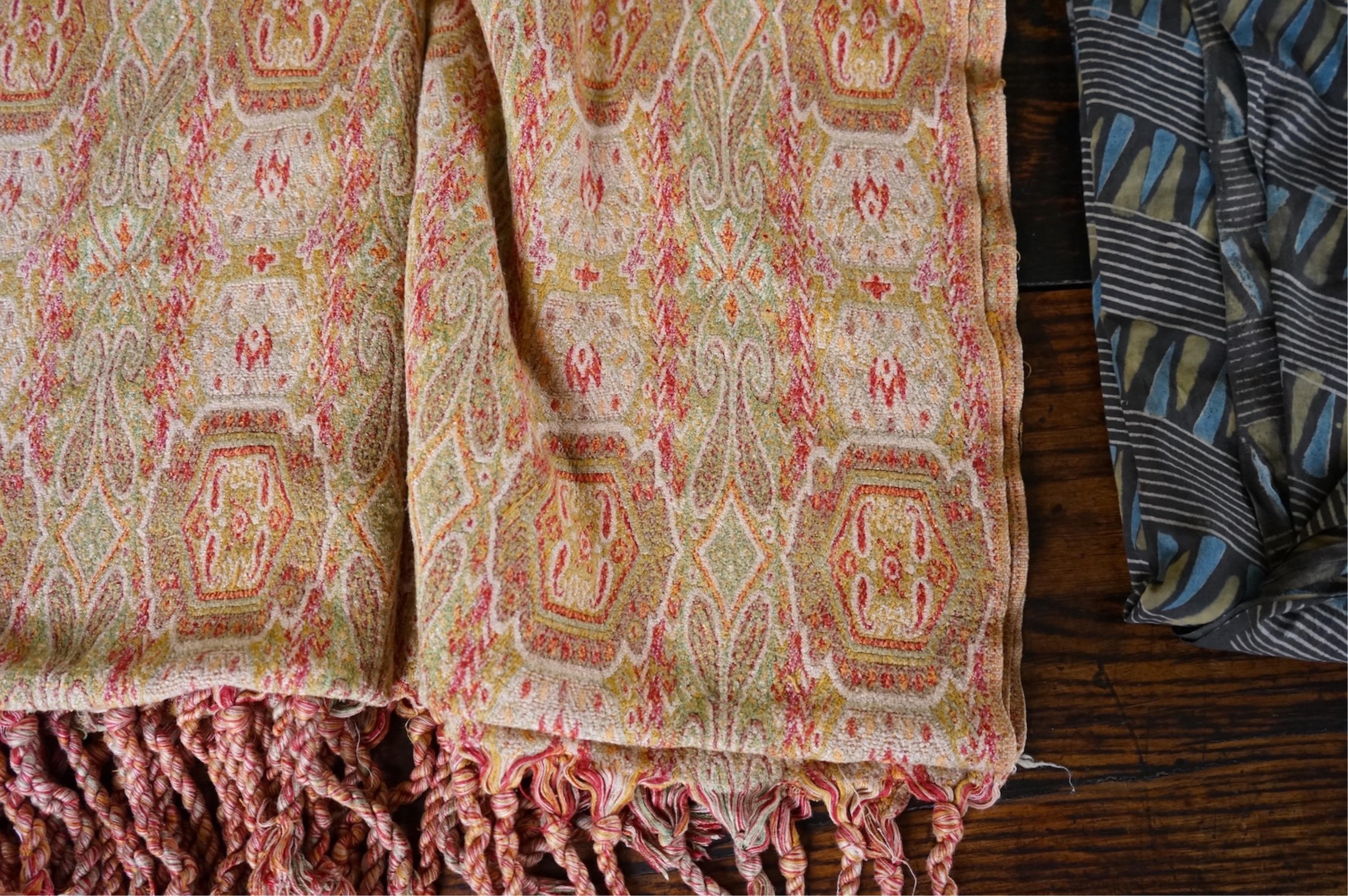A long narrow length of grey Ikat woven fabric, a roll of Indian mirrored edging, a geometric batik printed length and a woven paisley ‘style’ tasselled stole. (4). Batik 392cm long x 108cm wide., Condition - good, all a